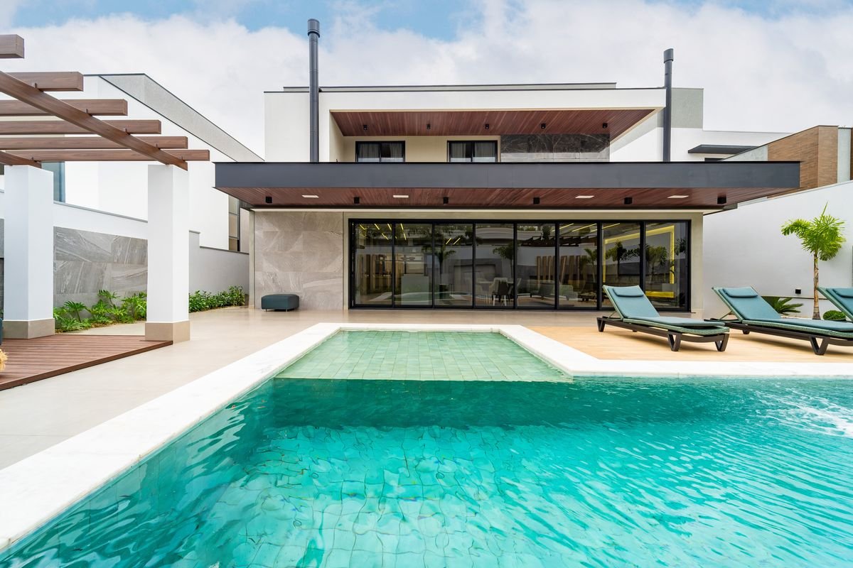 Área externa com piscina, deck e fachada envidraçada