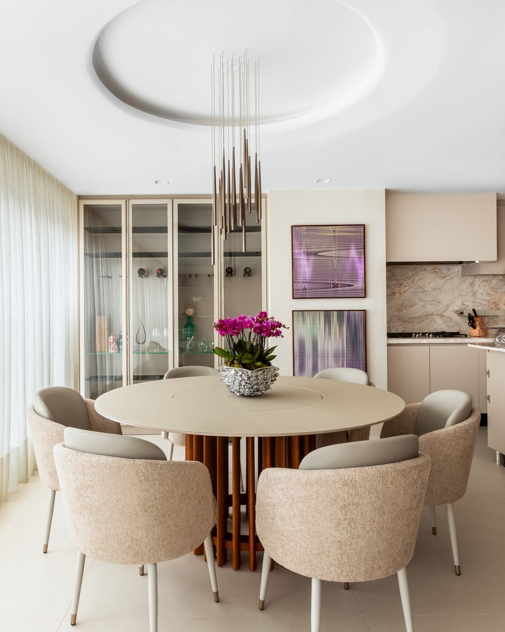 Sala de jantar com mesa redonda e cristaleira